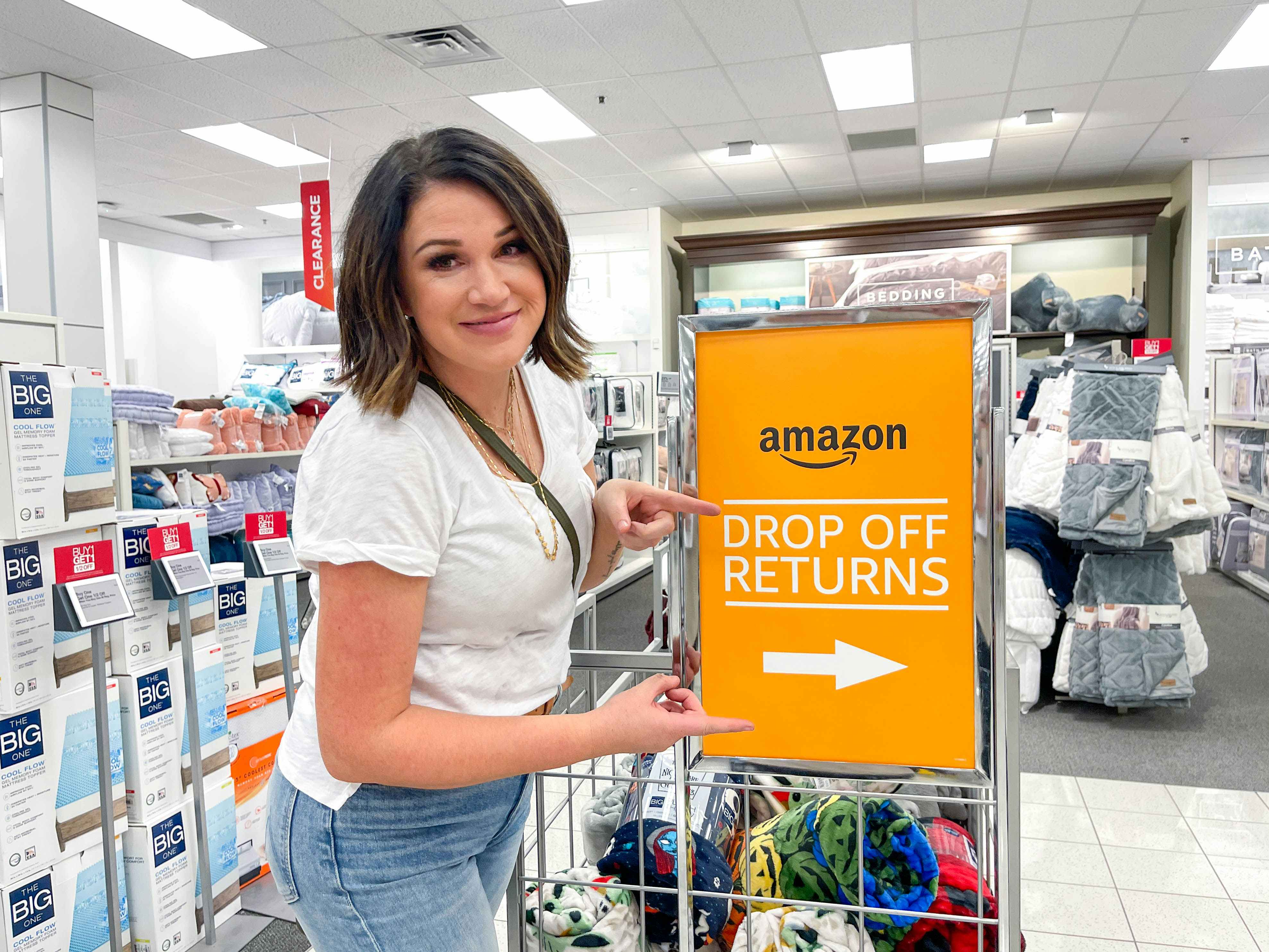 Joanie pointing to an Amazon drop off Returns sign at Kohl's 