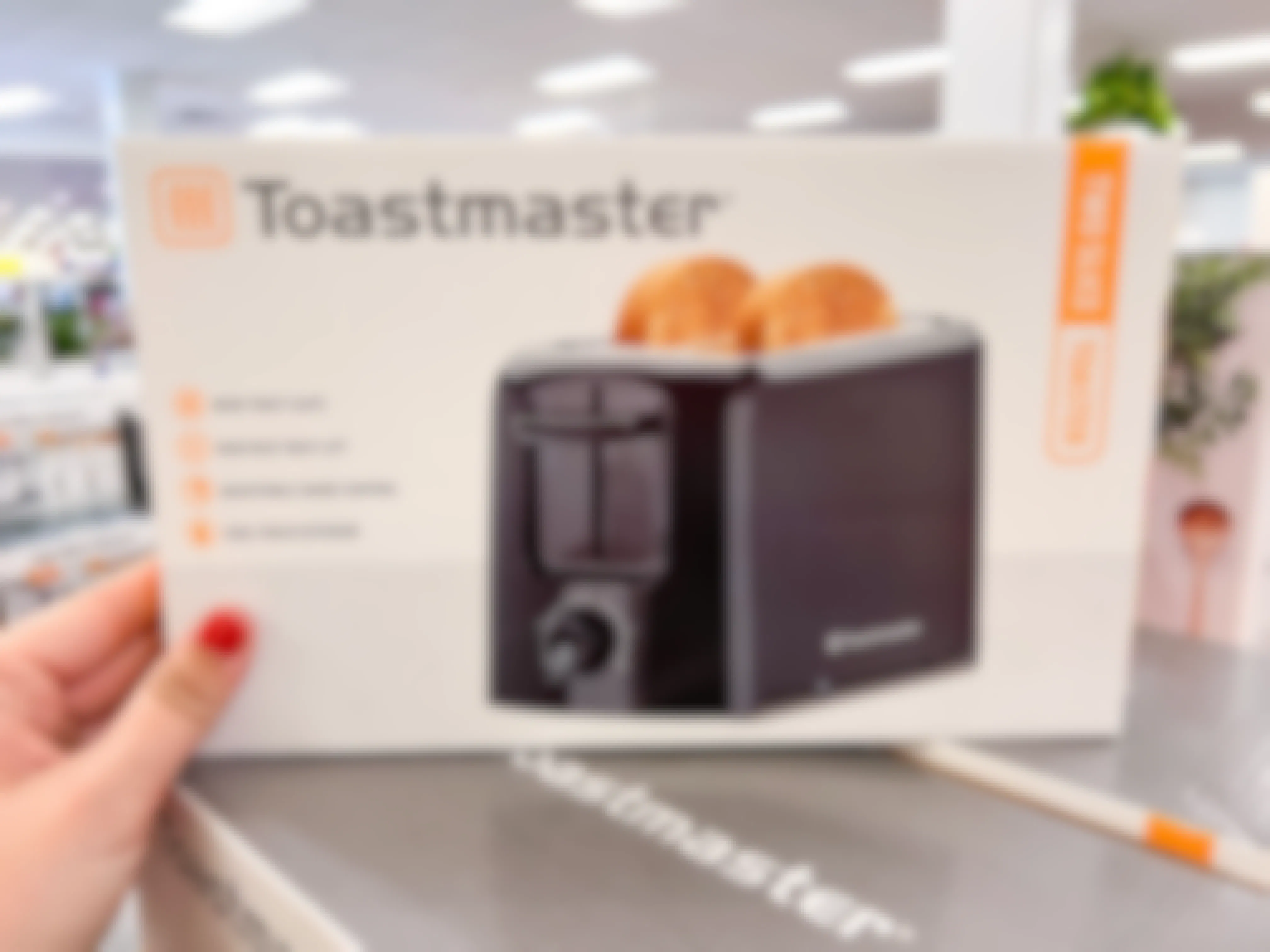 a person holding up a toastmaster toaster at kohls