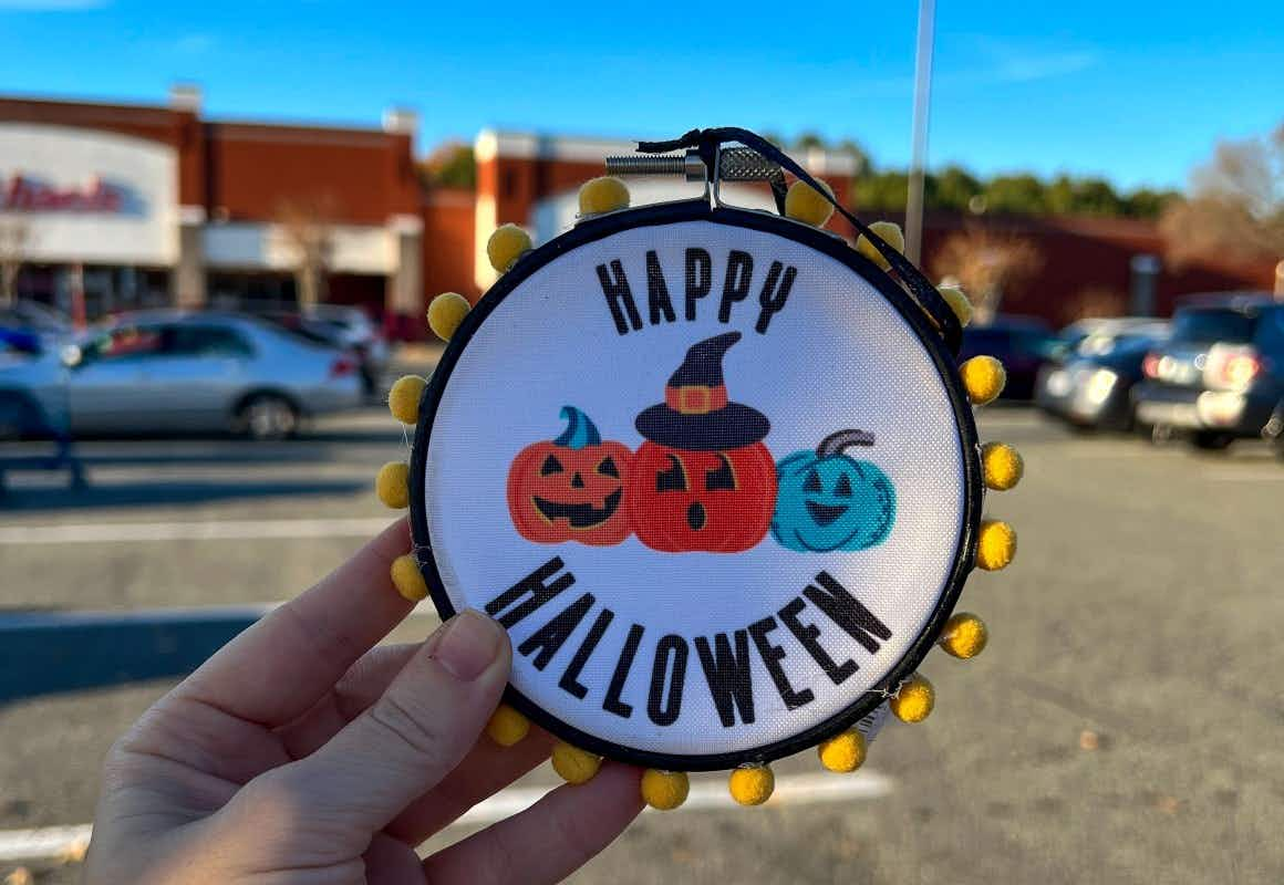 someone holding a small sign that says happy halloween