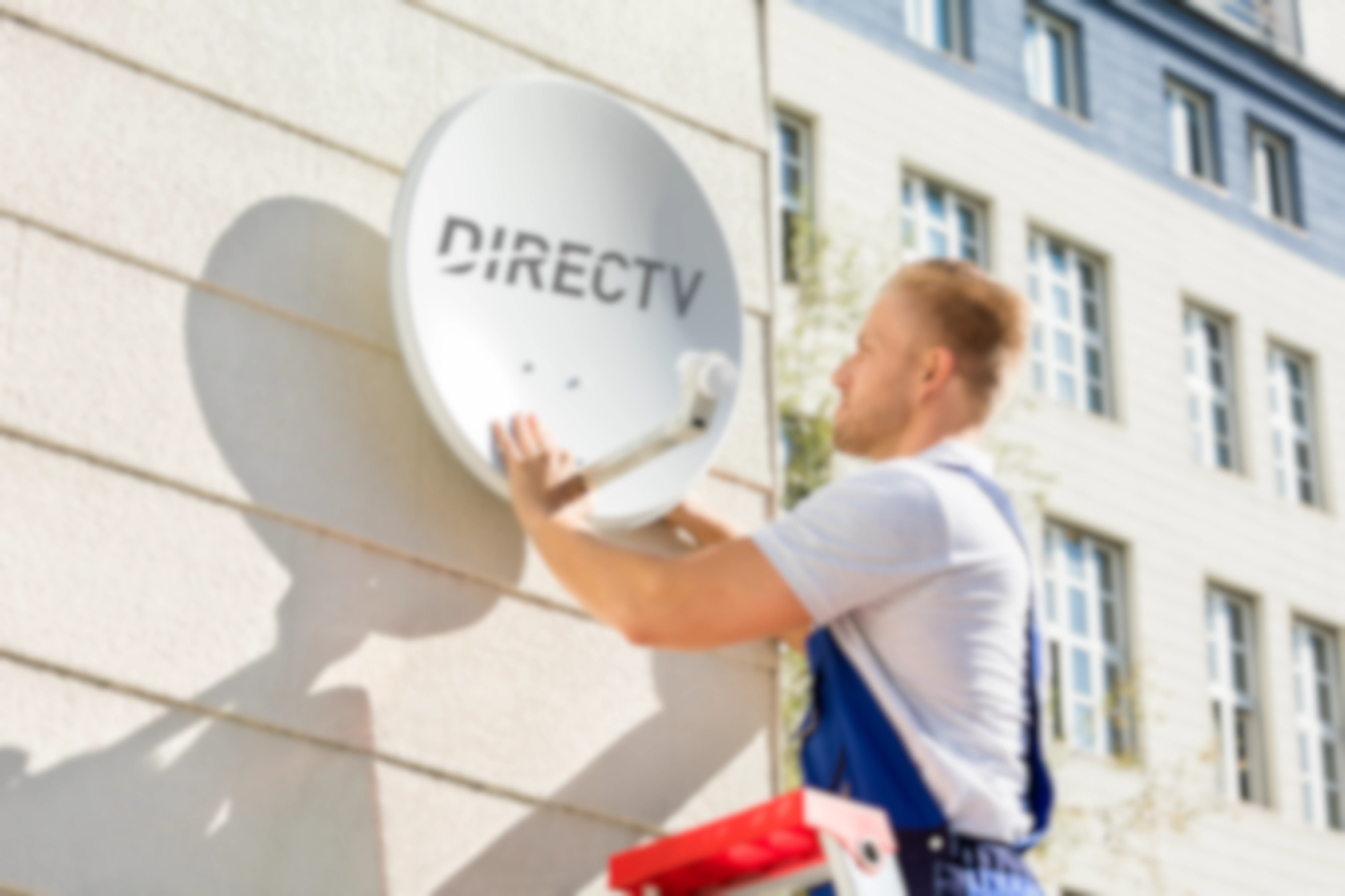 A man installing a direct tv dish