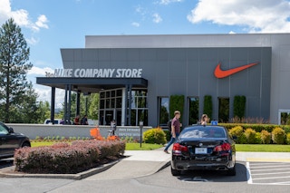The exterior of a Nike Company Store with people walking outside