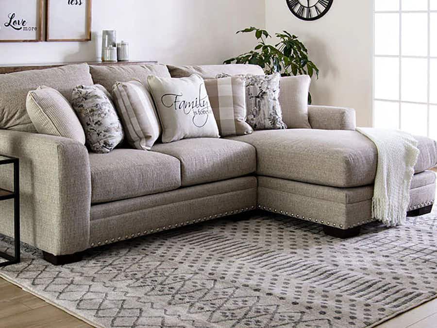 Grey sectional couch with pillows.