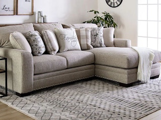 Grey sectional couch with pillows.