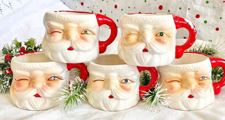 vintage santa mugs - A collection of Hand-Painted Winking Santa Face Mugs on a table decorated with holiday decorations