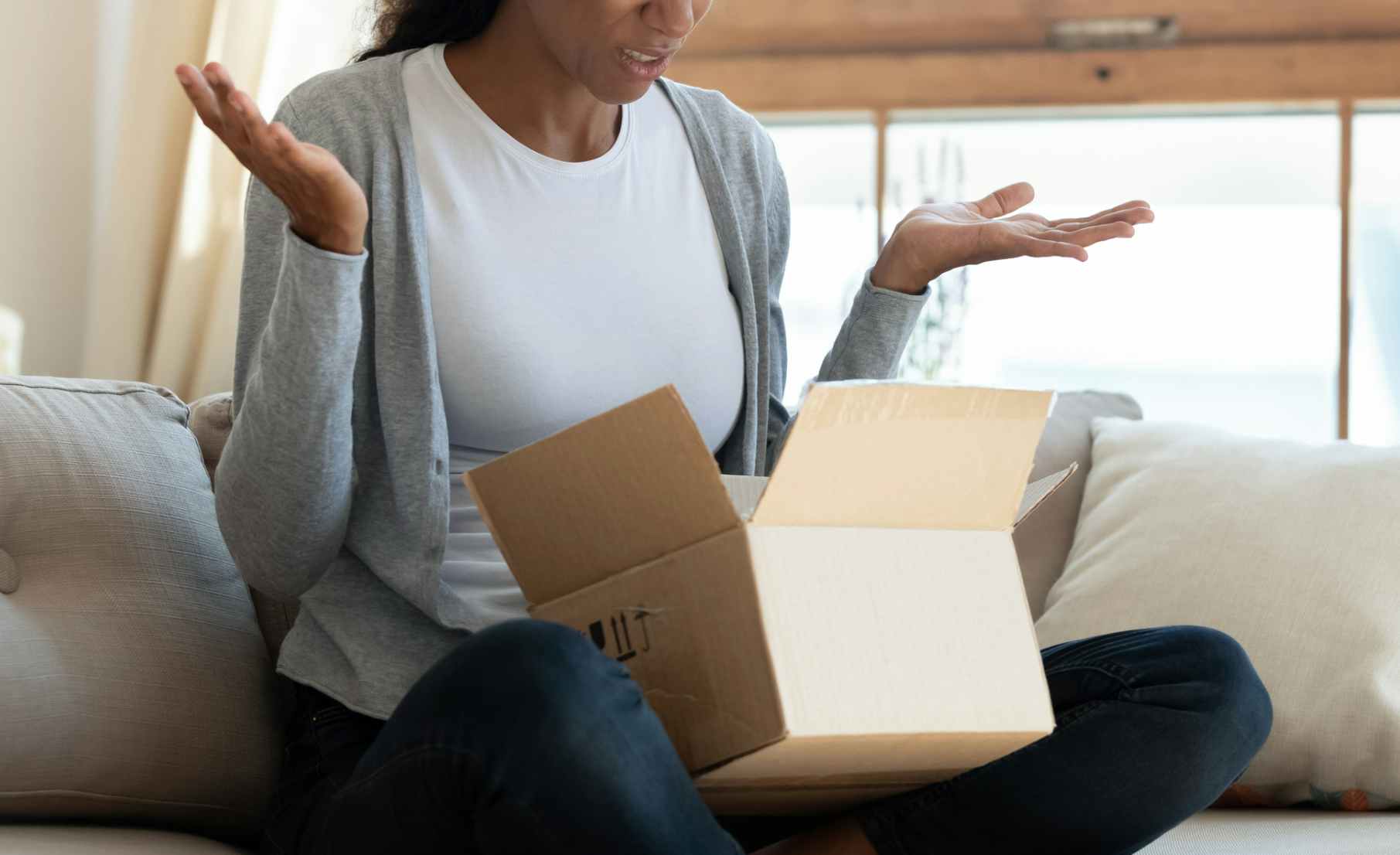 Woman looking upset about her online purchase (but even more upset since she'll have to pay for returns)