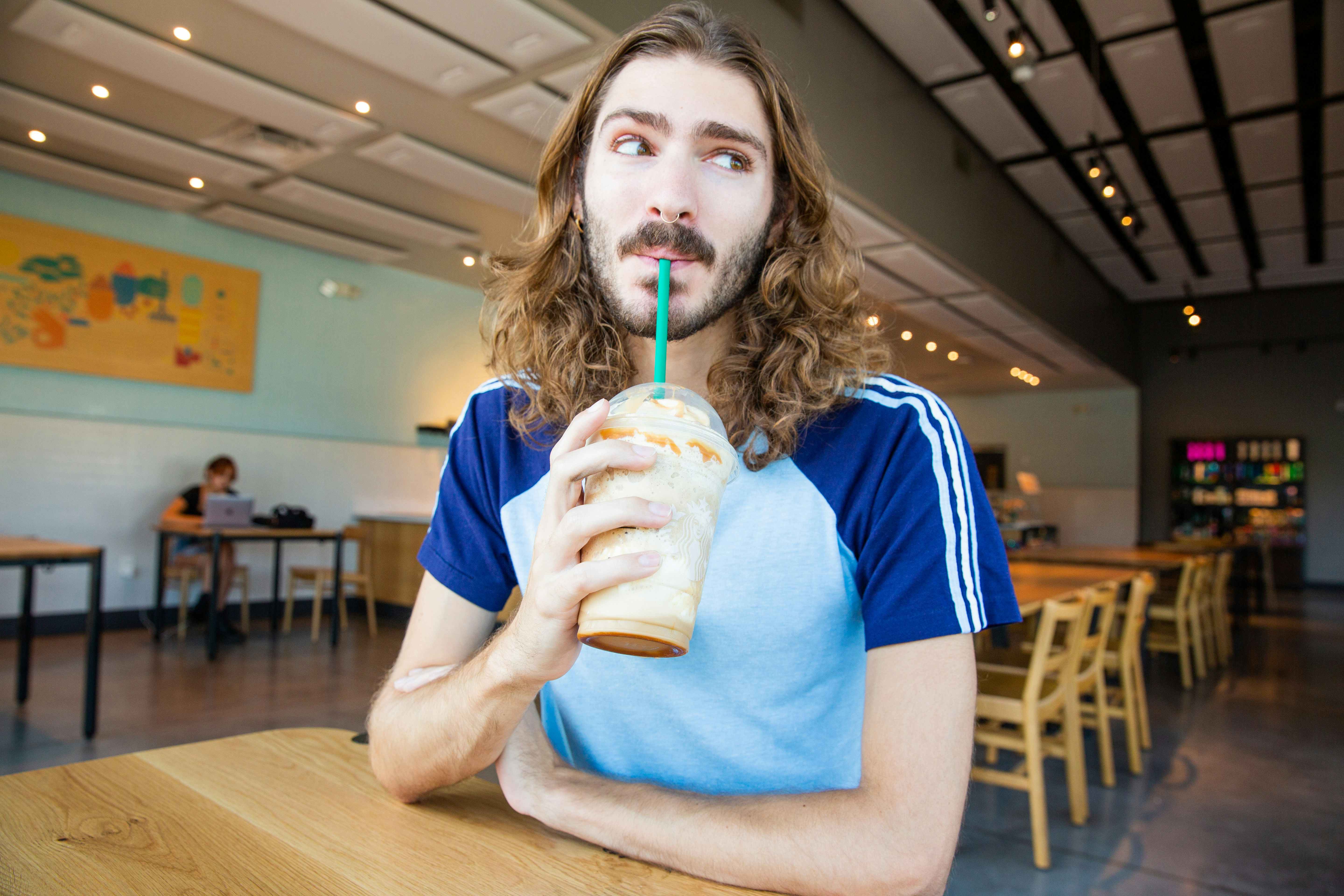 Person sipping through a straw, drinking a starbucks frapuccino