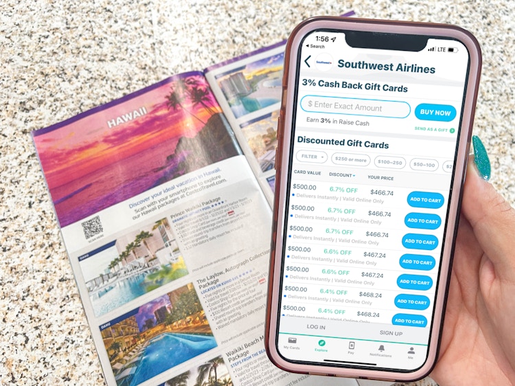 a person holdoing a cellphone with raise southwest discount gift card in front of hawaii brochure 