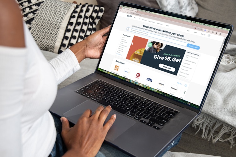 a person on a laptop looking up raise website while sitting on a couch 