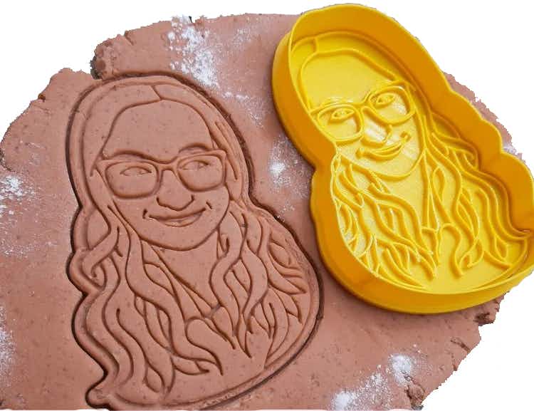 a personalized cookie cutter of a person being used on dough