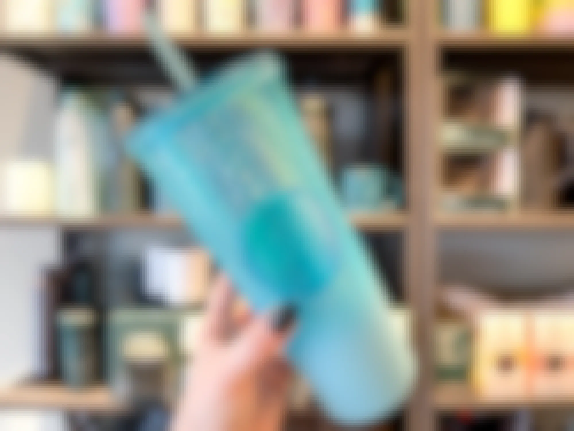 person holding turquoise jeweled starbucks winter tumbler with straw 2023
