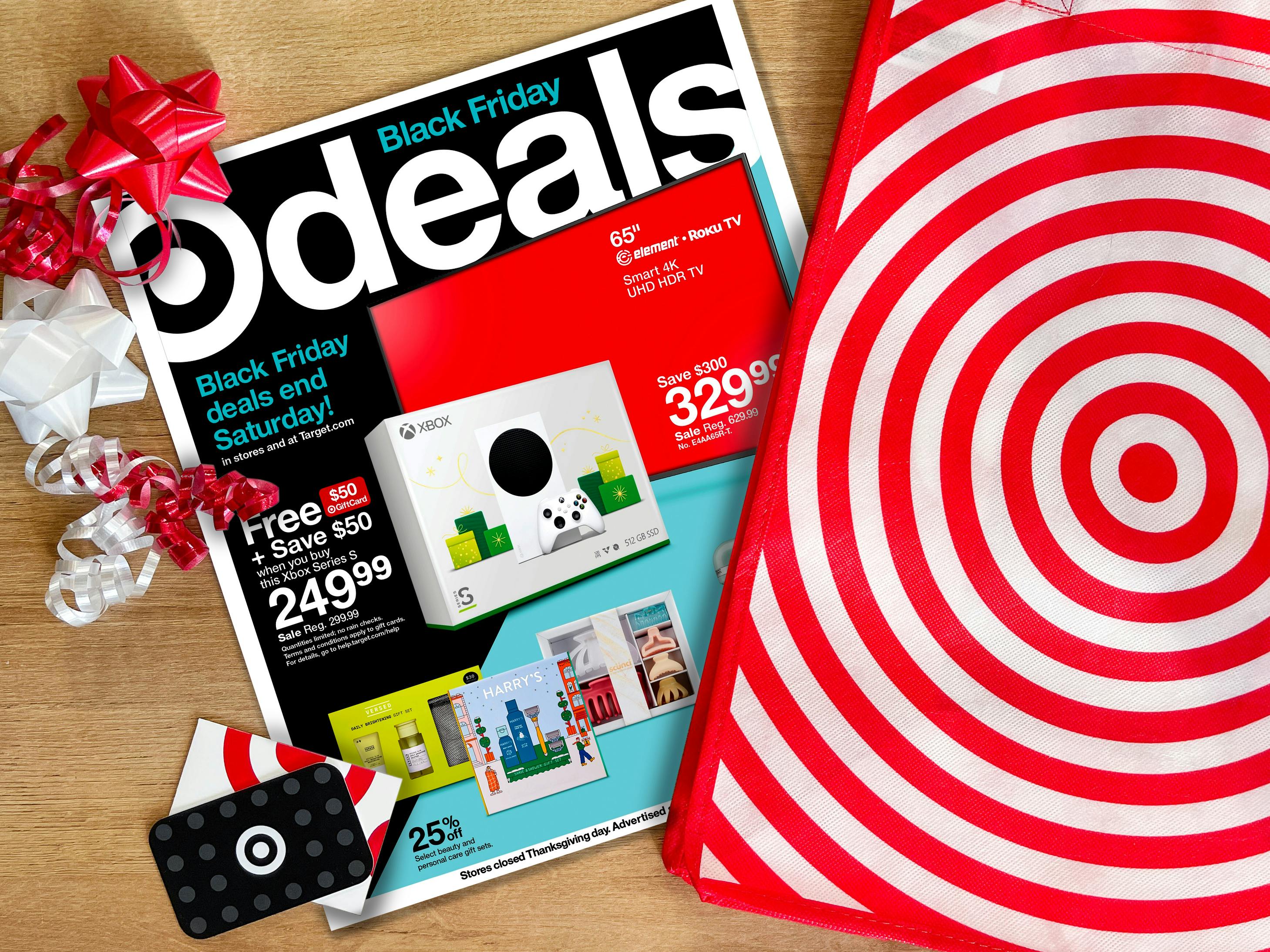 A Target Black Friday 2022 advertisement on a table with a Target bag, gift cards, and gift bows