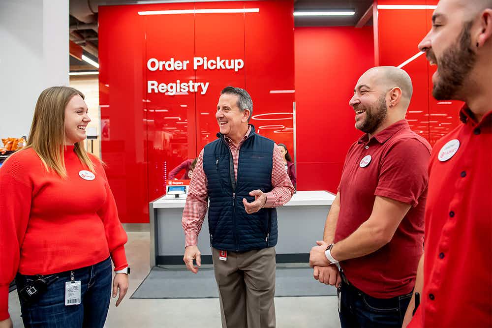 Target employees discussing something in front of the order pickup and registry desk inside Target