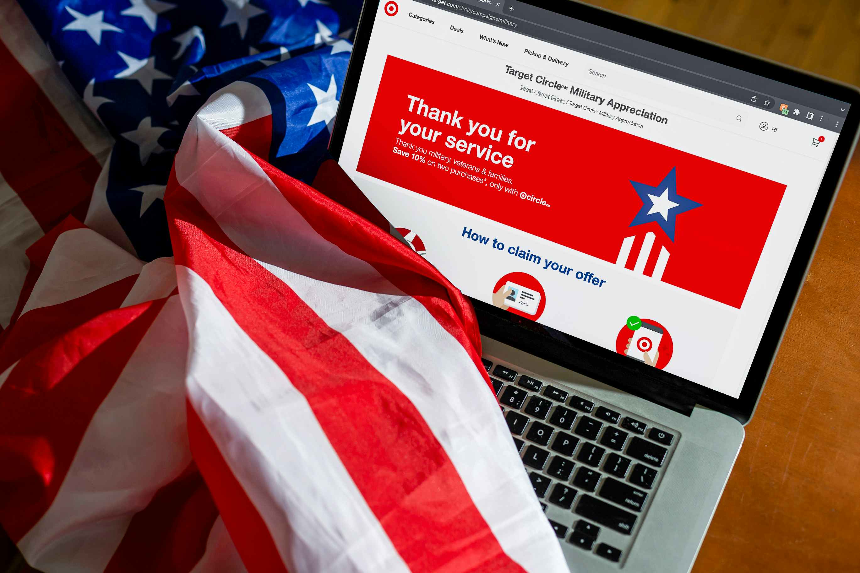 An American flag draped over a laptop displaying the Target webpage for their military discount program