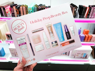 Someone holding a Holiday Prep Beauty Box in front of a shelf of makeup at Target
