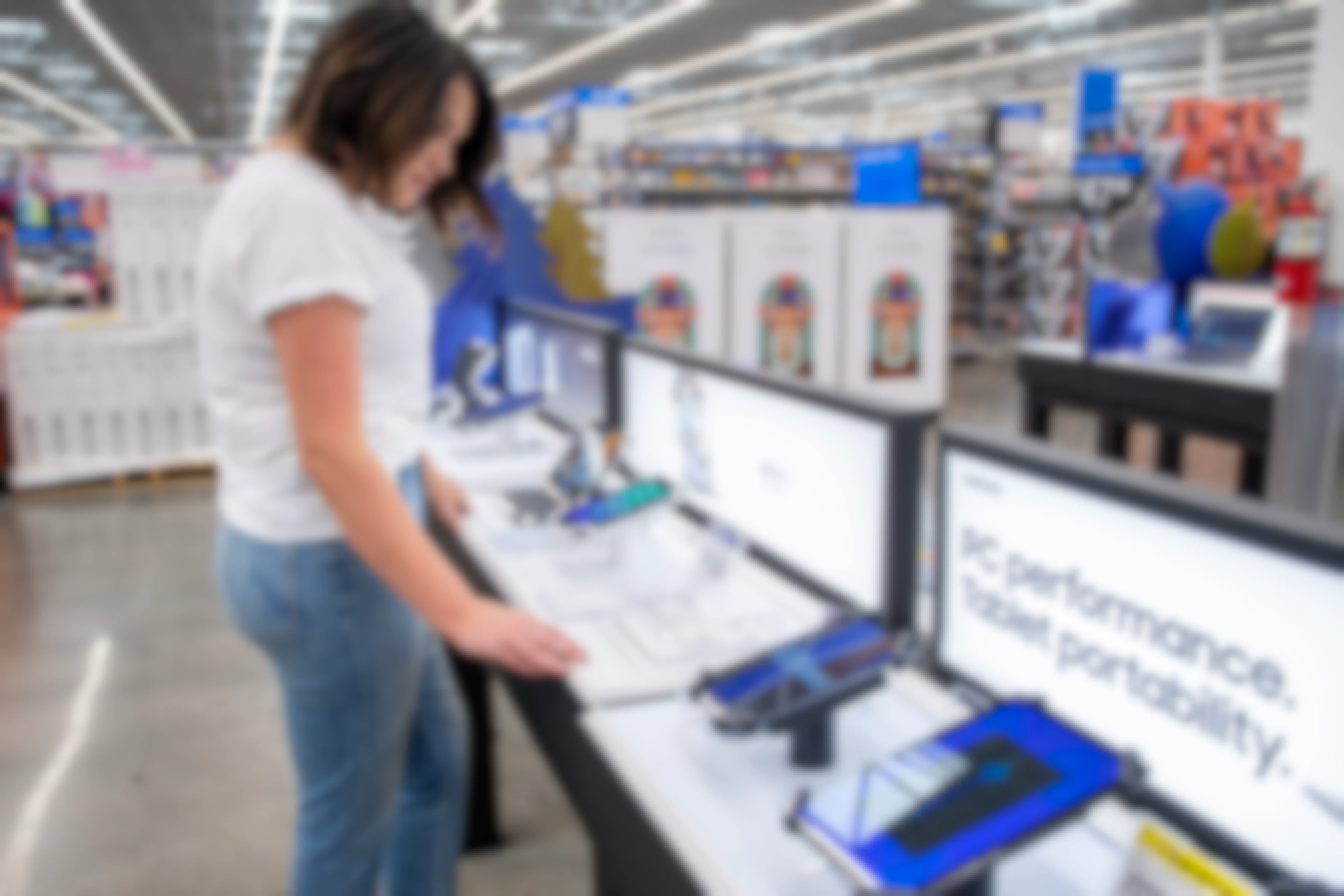 A woman looking at Samsung tablets in Walmart's electronics department