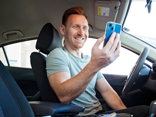 Person in their car while looking at their phone