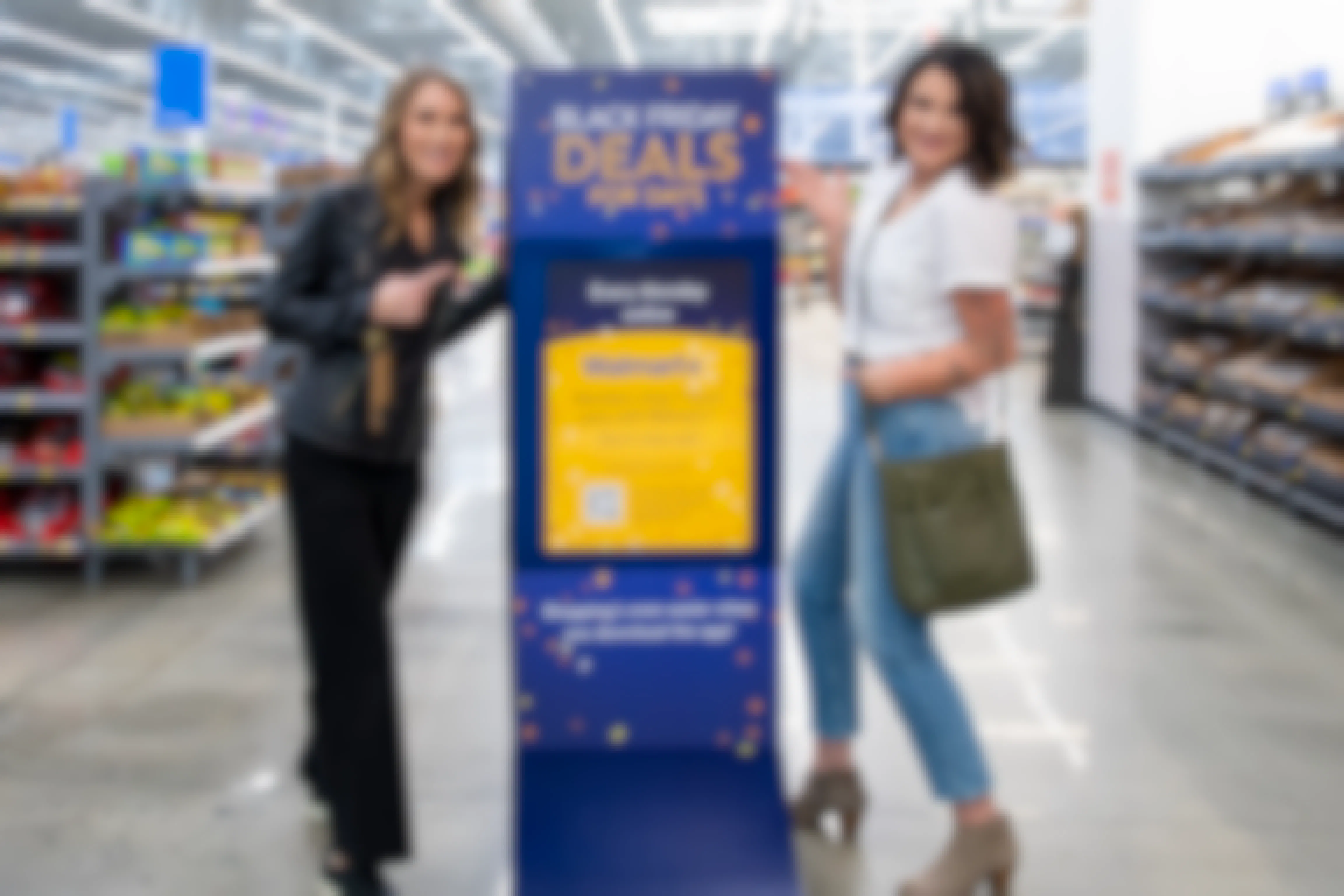 Two women standing by and pointing at a Black Friday Walmart Deal days sign.