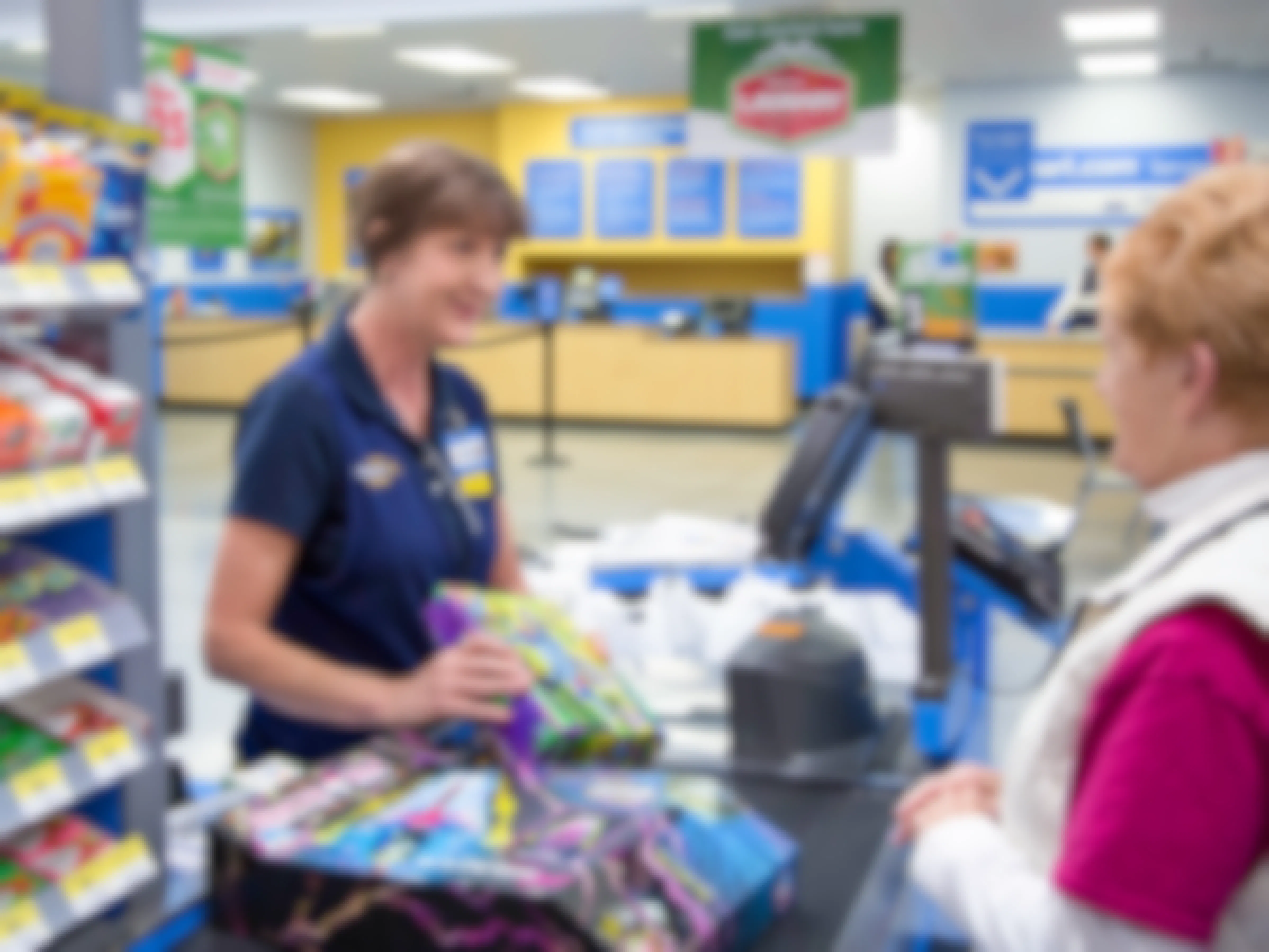 A Walmart employee scanning items for a customer at the checkout counter.