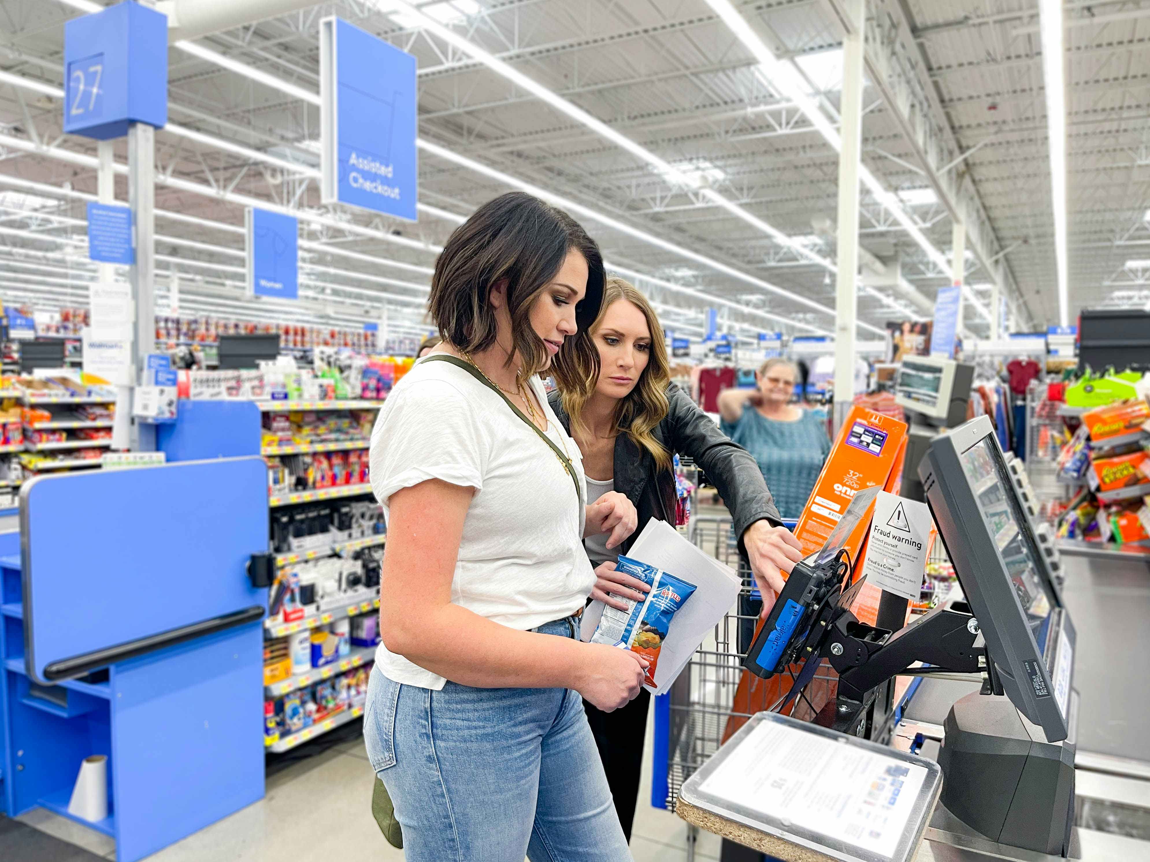 two woman checking out at walmart