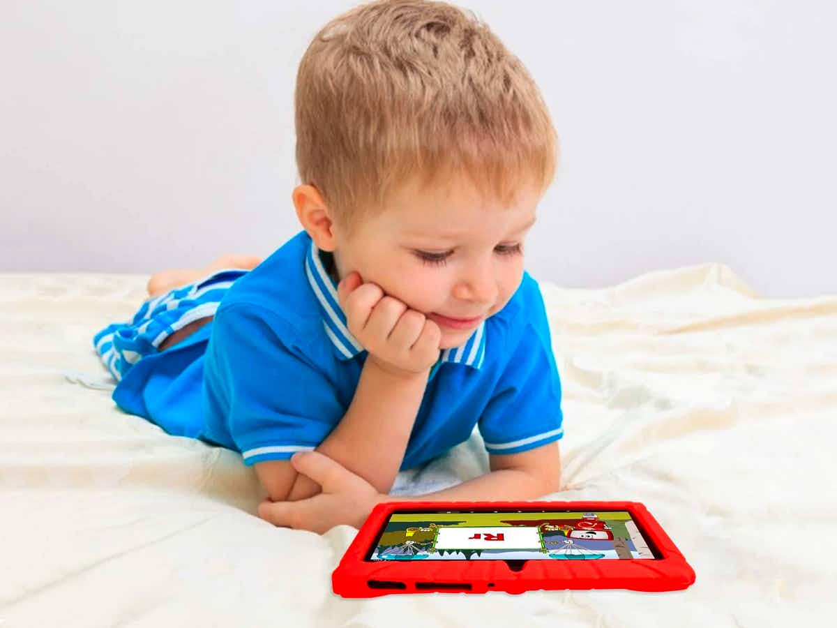 A little kid looking at a Contixo learning tablet