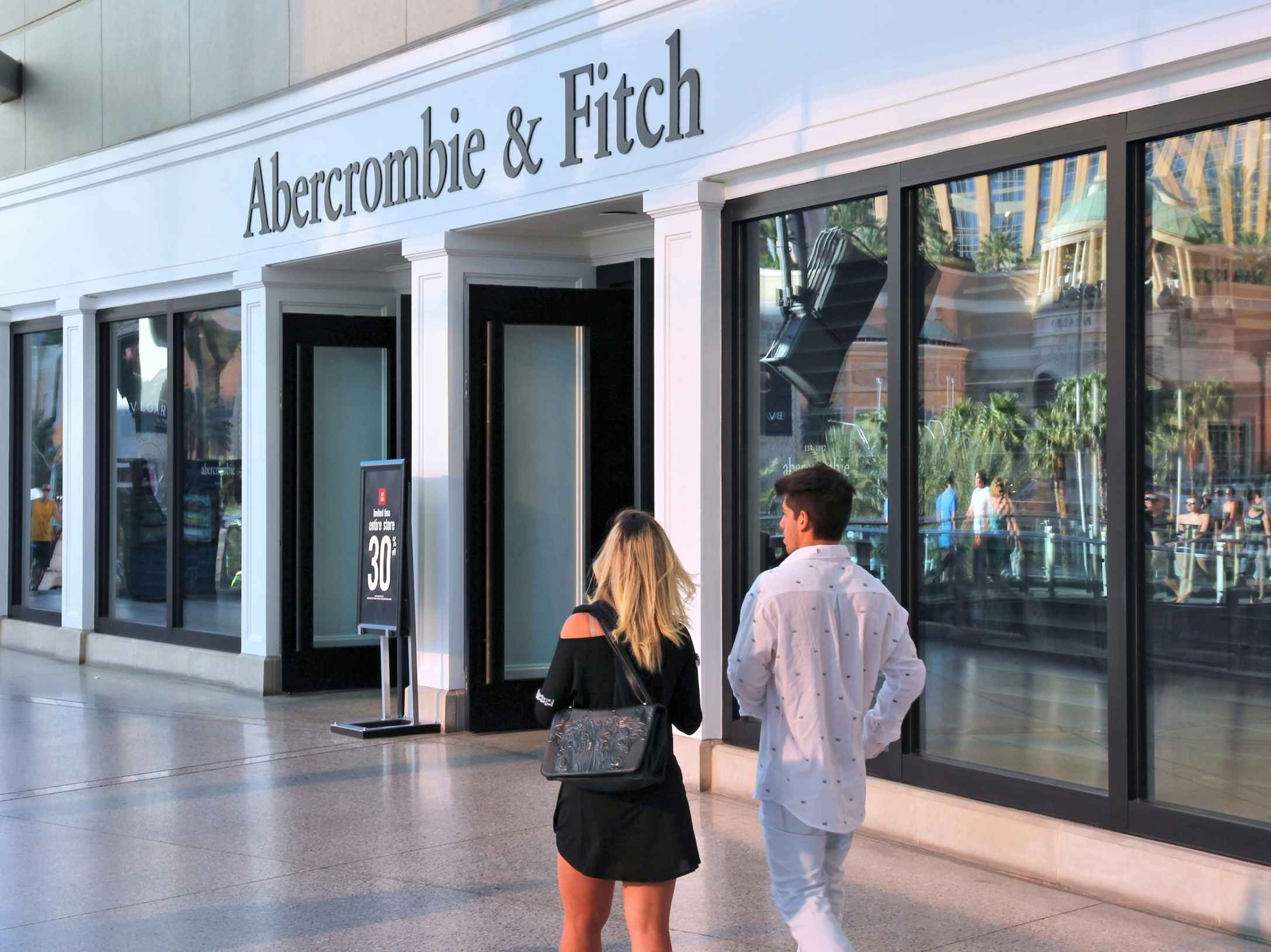 Two people walking toward an Abercrombie & Fitch store