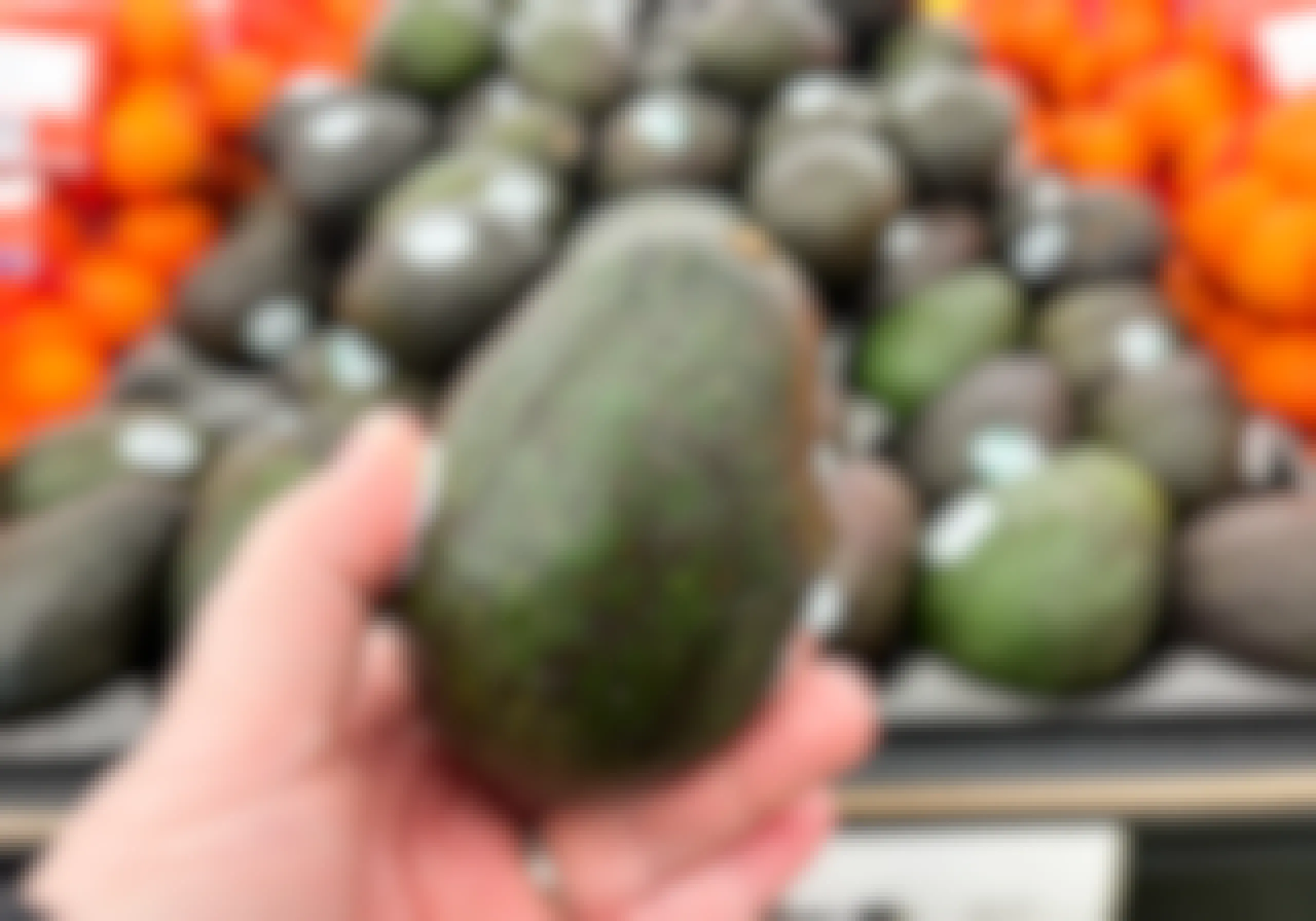 hand holding ripened avocado at store