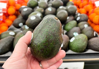 hand holding ripened avocado at store