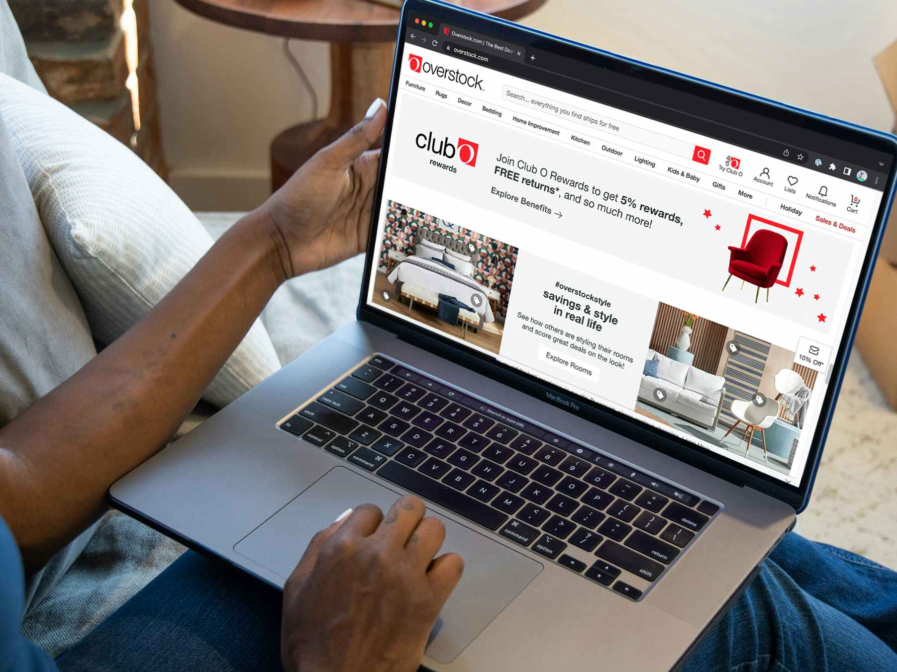 A person shopping on Overstock.com using a laptop