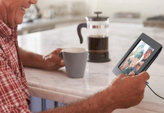 man-holding-digital-photo-frame-in-kitchen