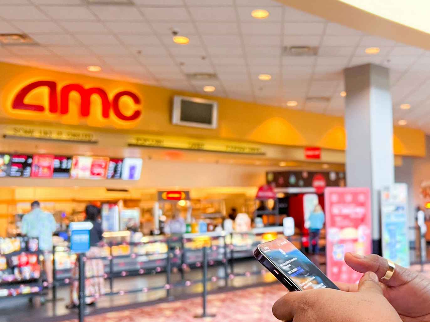 someone at an AMC theater looking at their phone