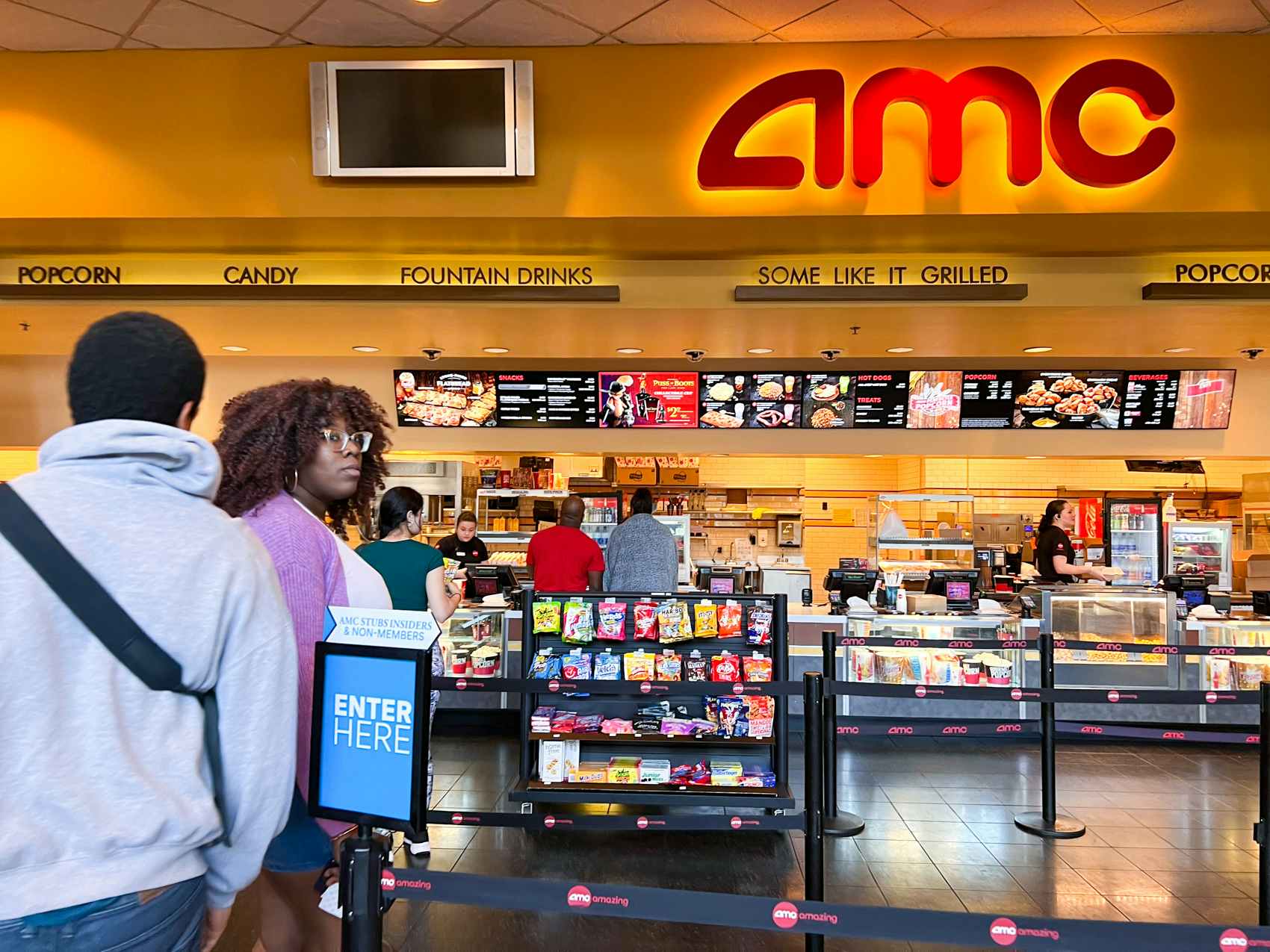 two people entering the concessions line at AMC