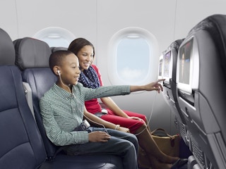 A mom and her son sitting in their seats on an American Airlines flight