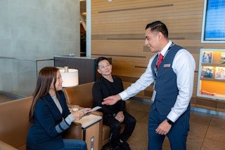 An American Airlines employee talking to a passenger at the gate