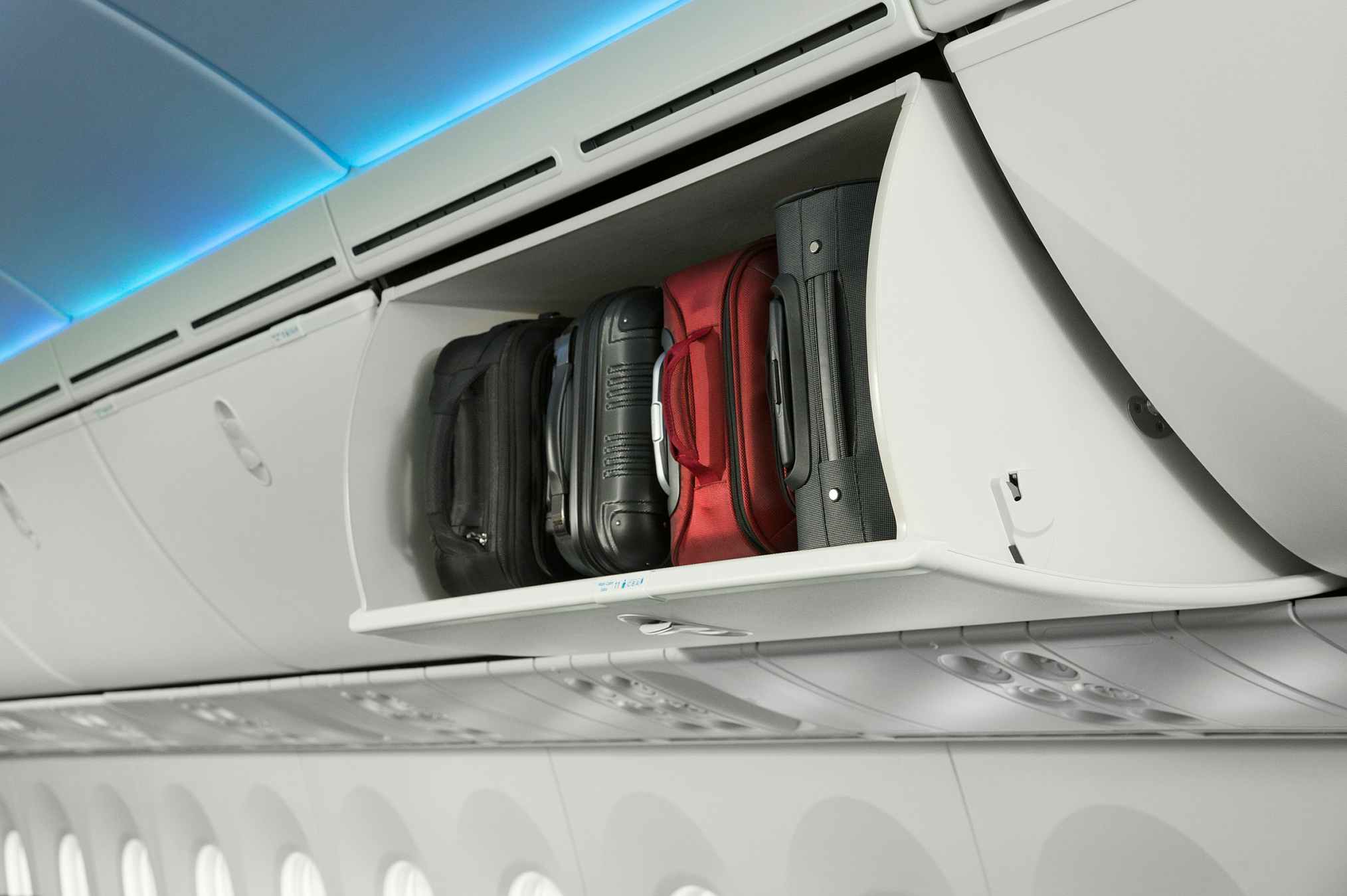 Carry-on bags in the storage compartment above the seats on an American Airlines plane