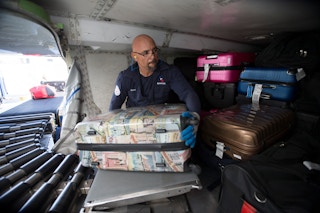 An American Airlines Fleet Service employee loading luggage onto a plane.