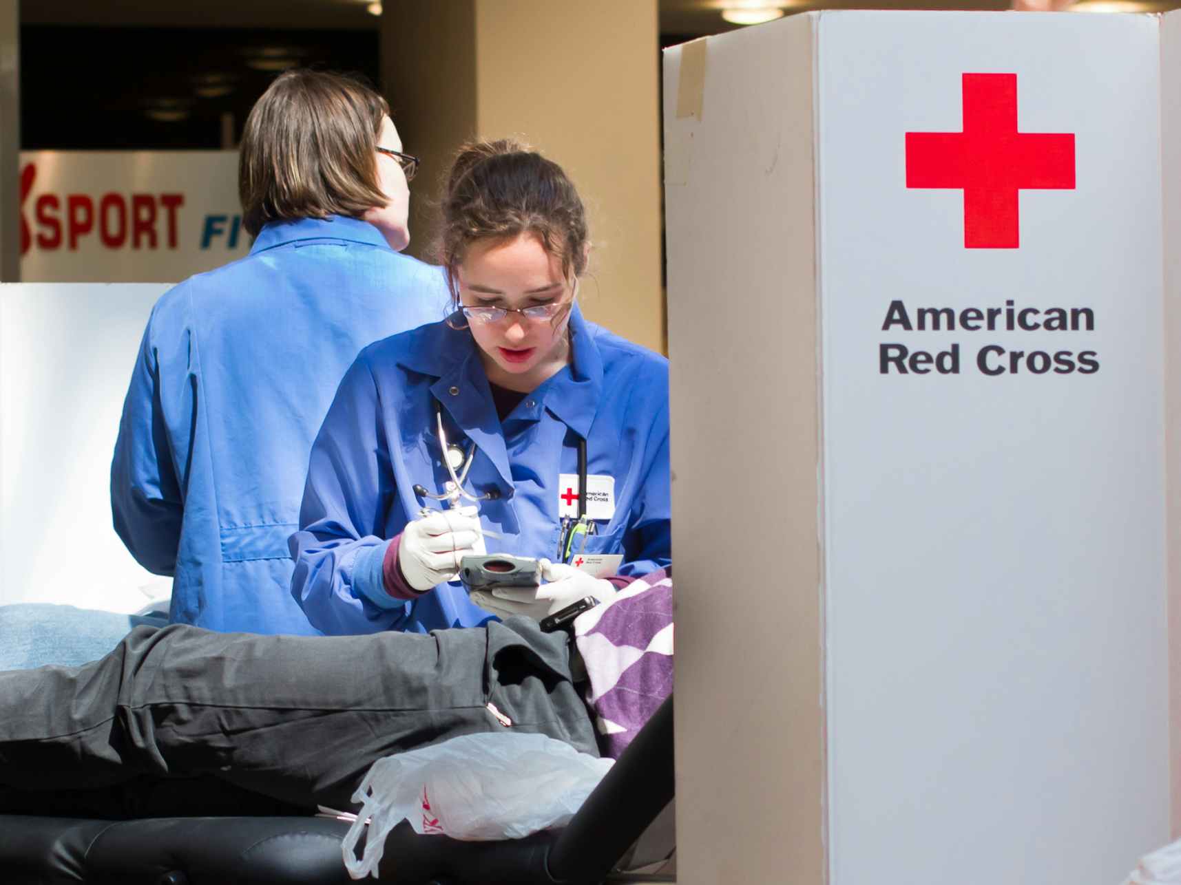 An American Red Cross healthcare professional taking blood from a donor