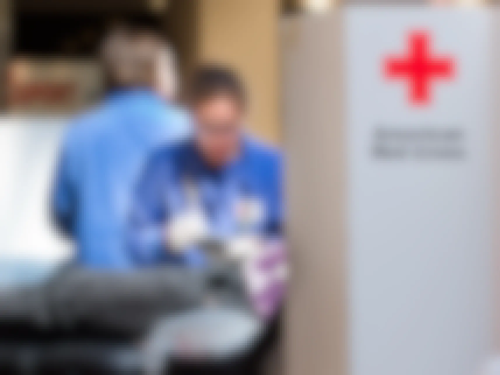 An American Red Cross healthcare professional taking blood from a donor