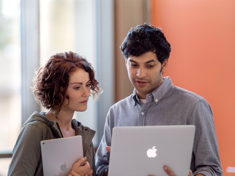 teachers in a school holding apple devices