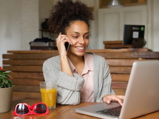 happy person talking on phone and working at laptop