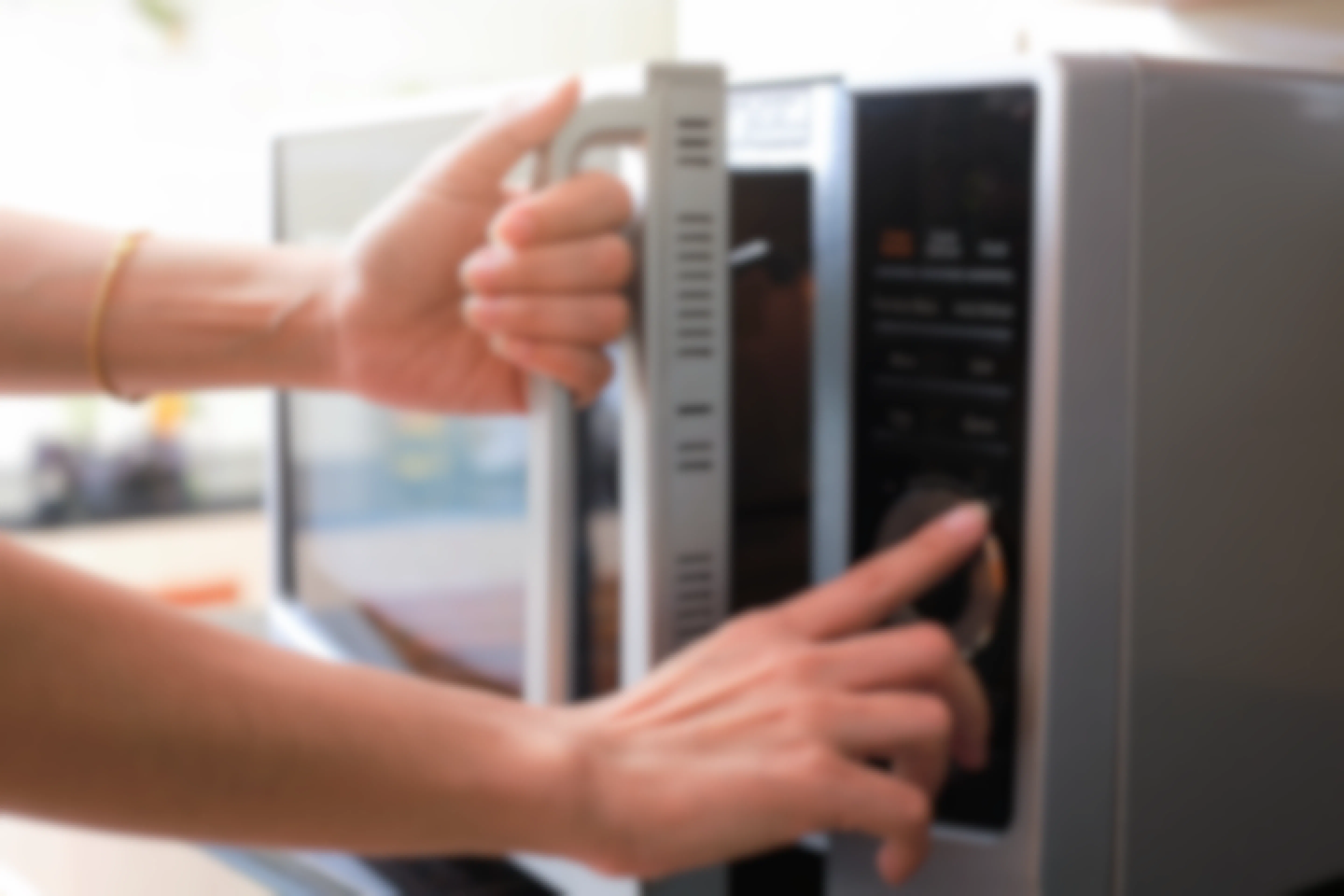 Person using and opening a microwave