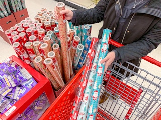 A person shopping for rolls of gift wrapping paper at Target
