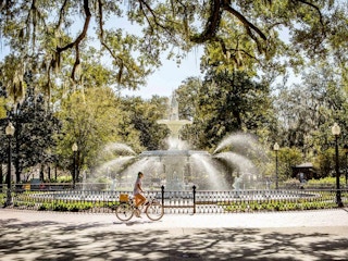 person riding bicycle around forsyth park fountain in savannah georgia