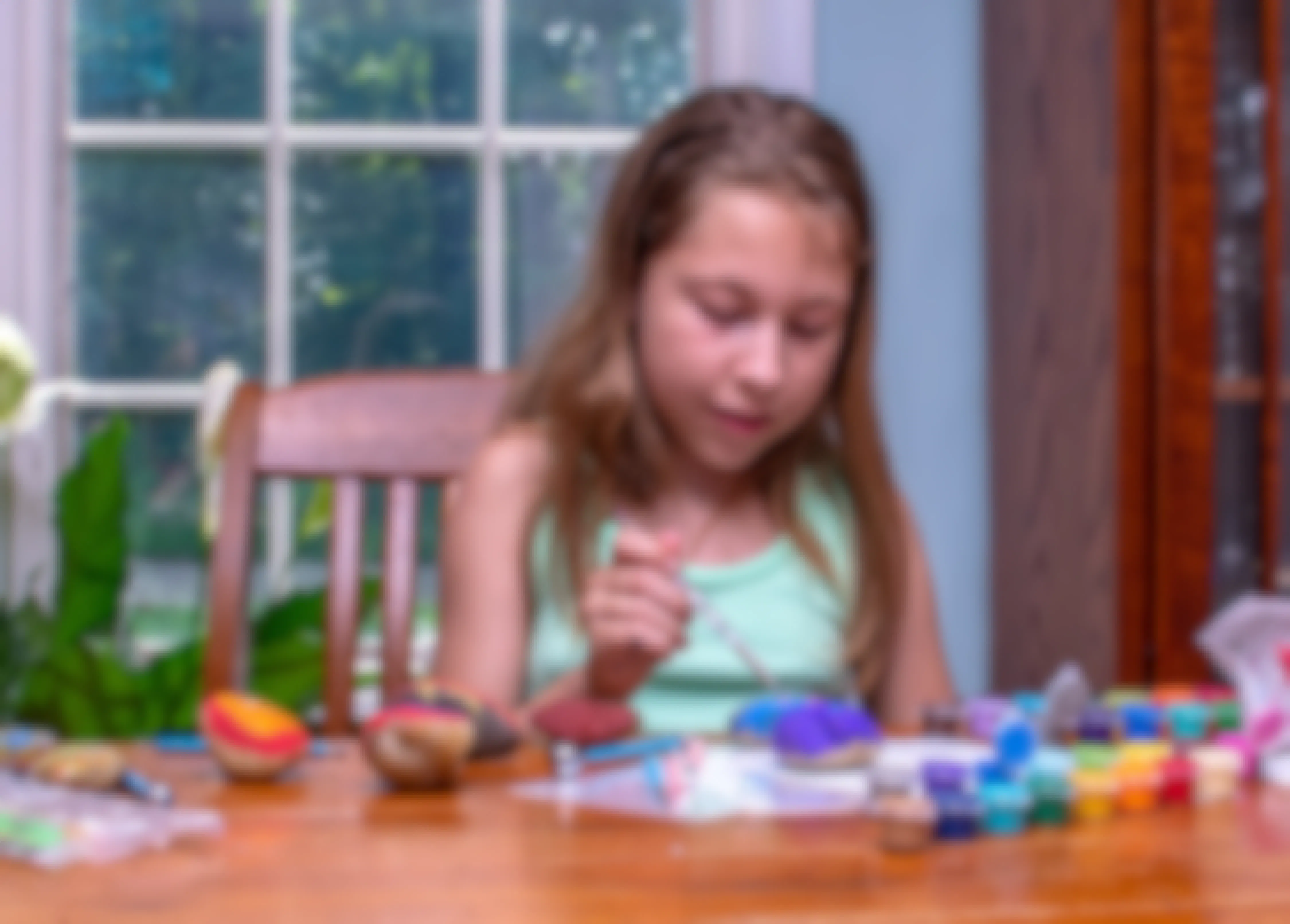 Child painting on rocks at home