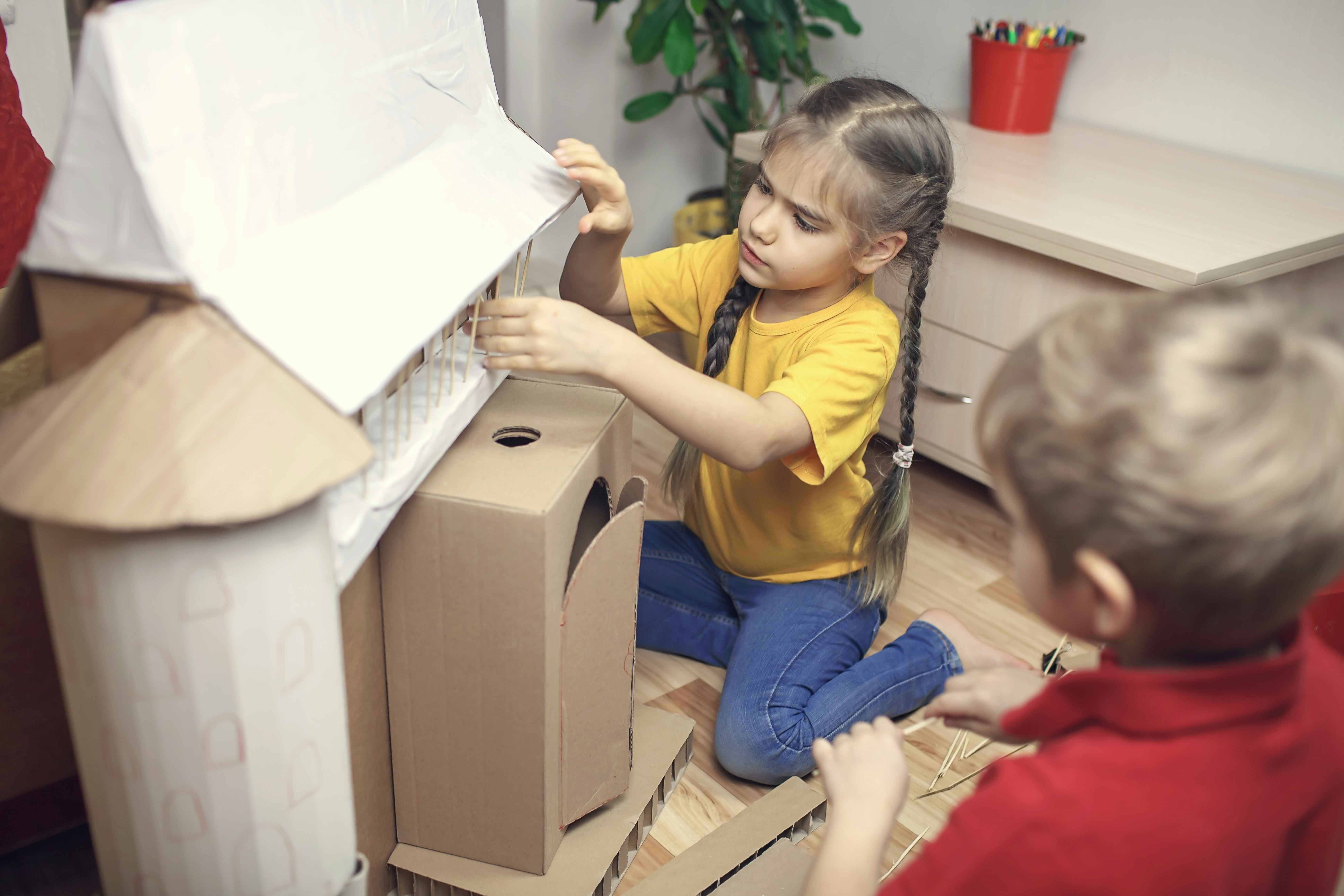 Kids creating a house with cardboard