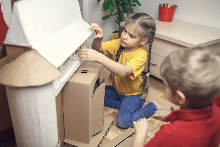 Kids creating a house with cardboard