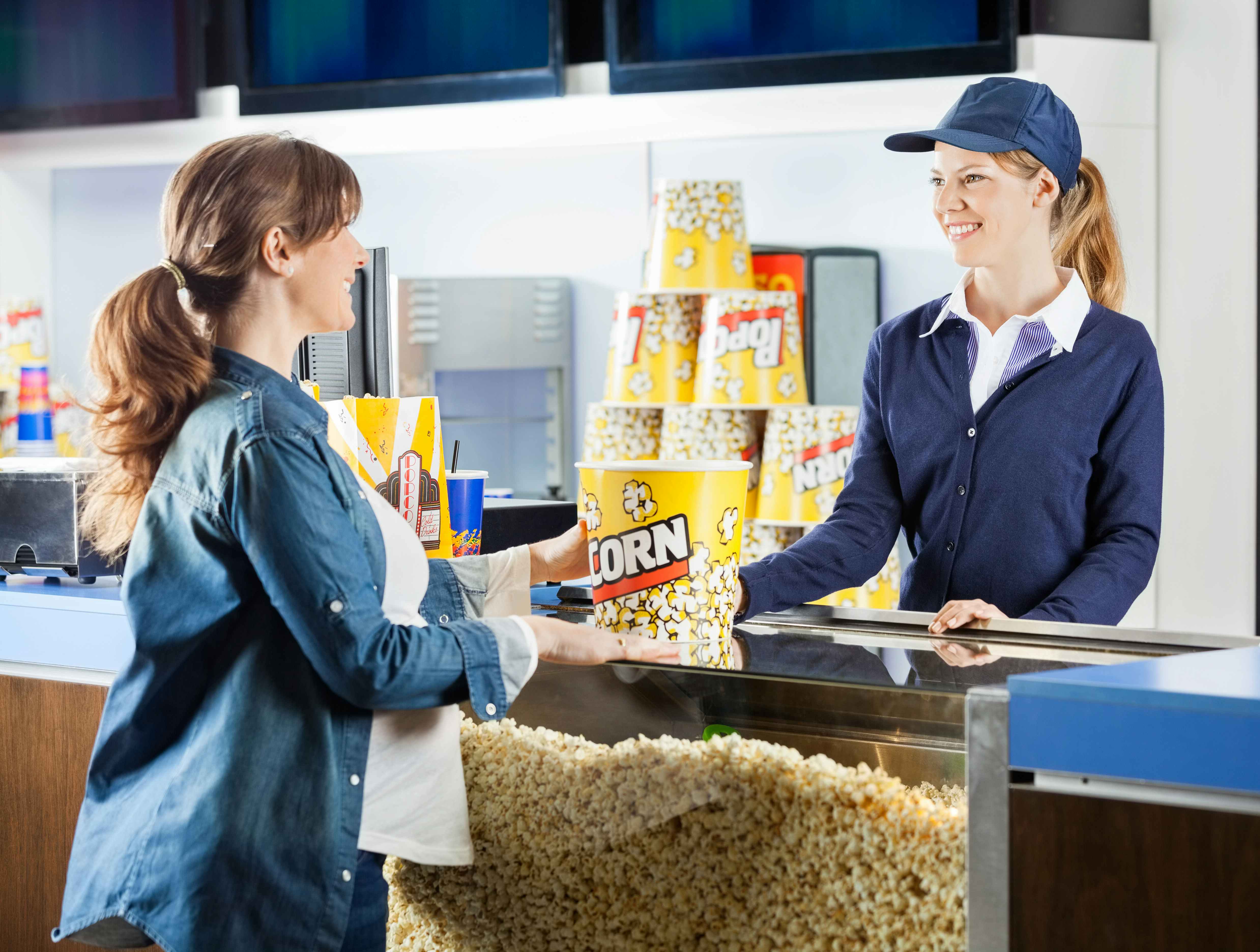 Person buying popcorn at a concession stand at the movie theater