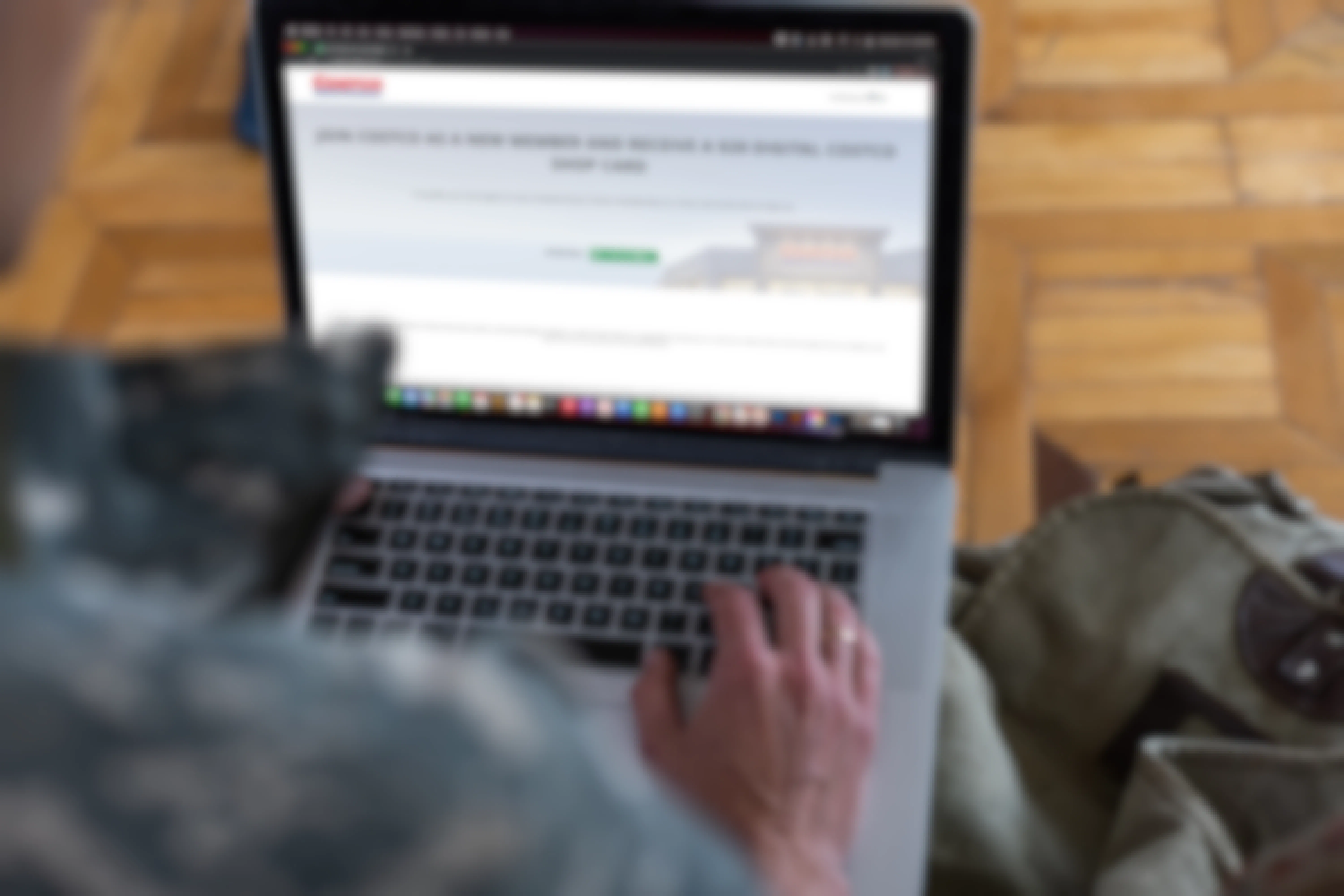 Person in uniform on a laptop with Costco Website open