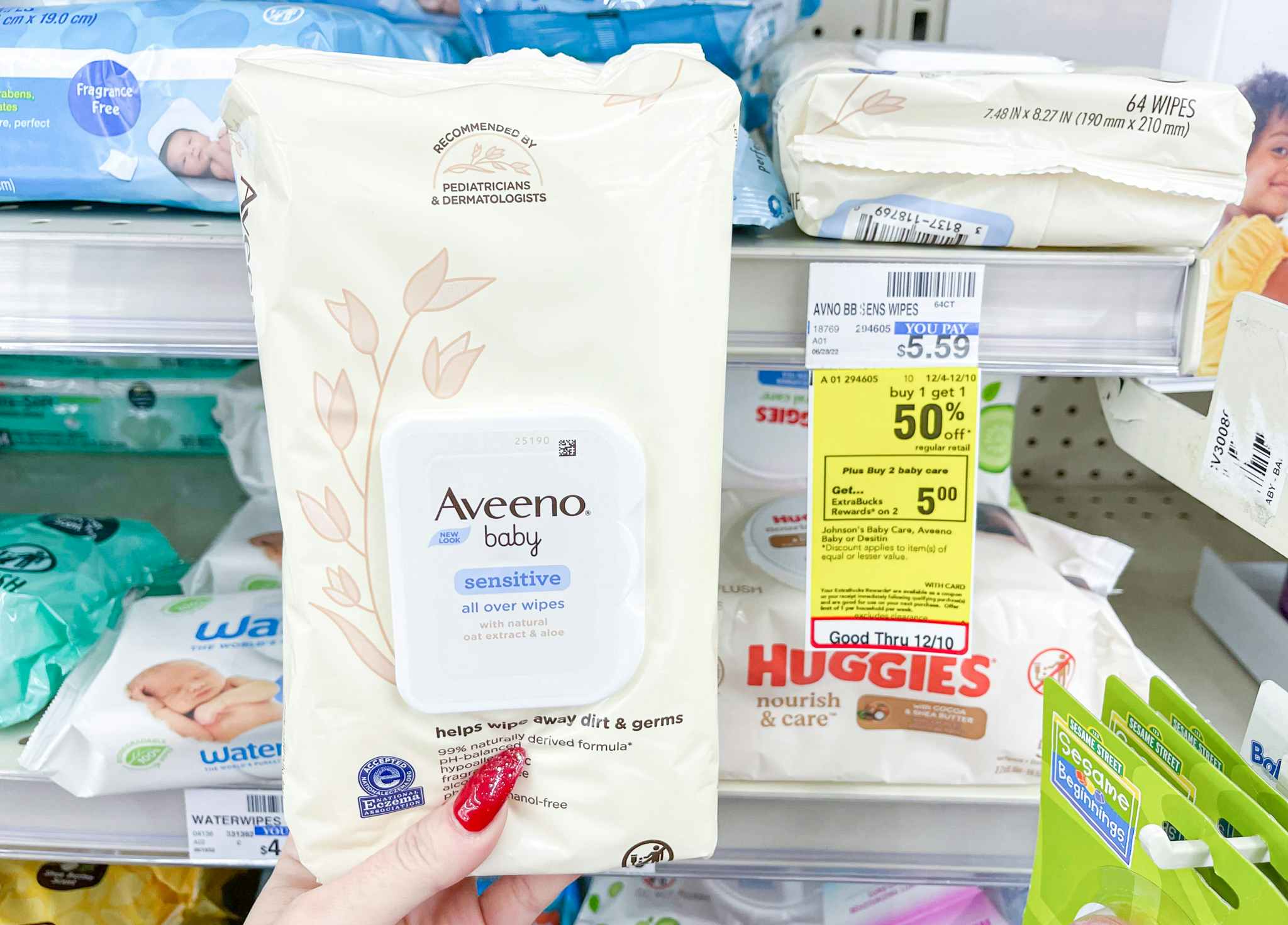 hand holding aveeno baby wipes next to sale tag
