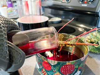 wax being pouring into christmas tin