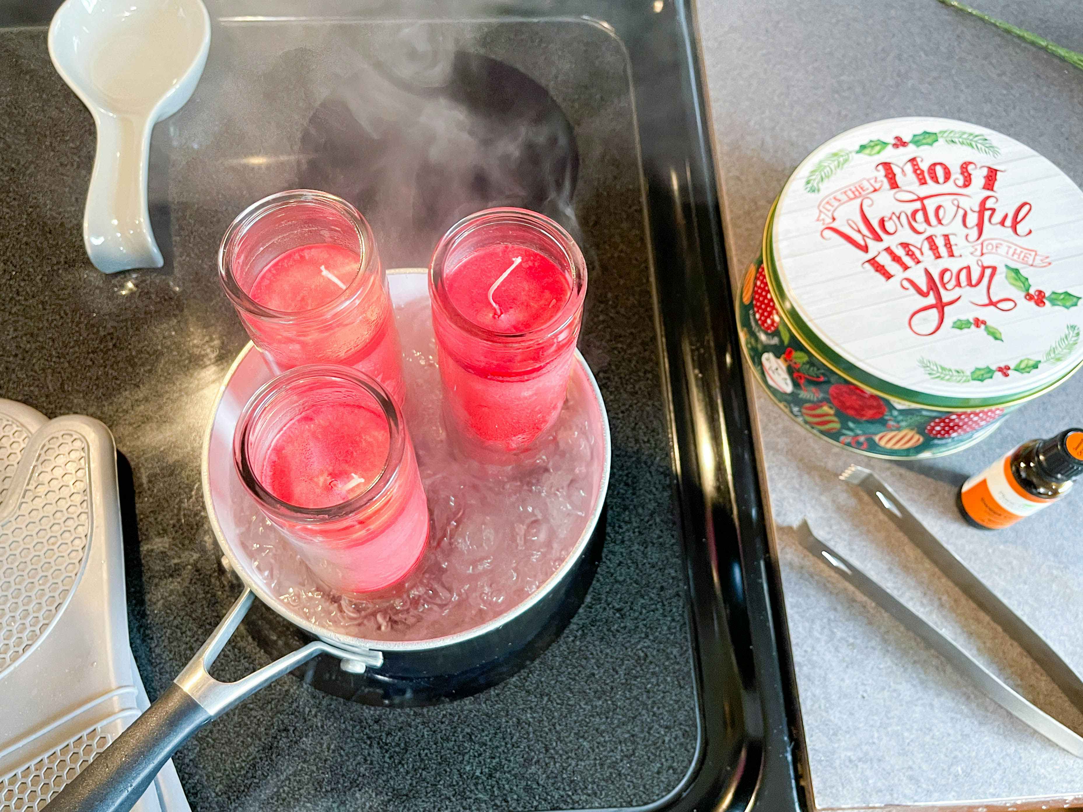 three candles being melted down in a pot of boiling water